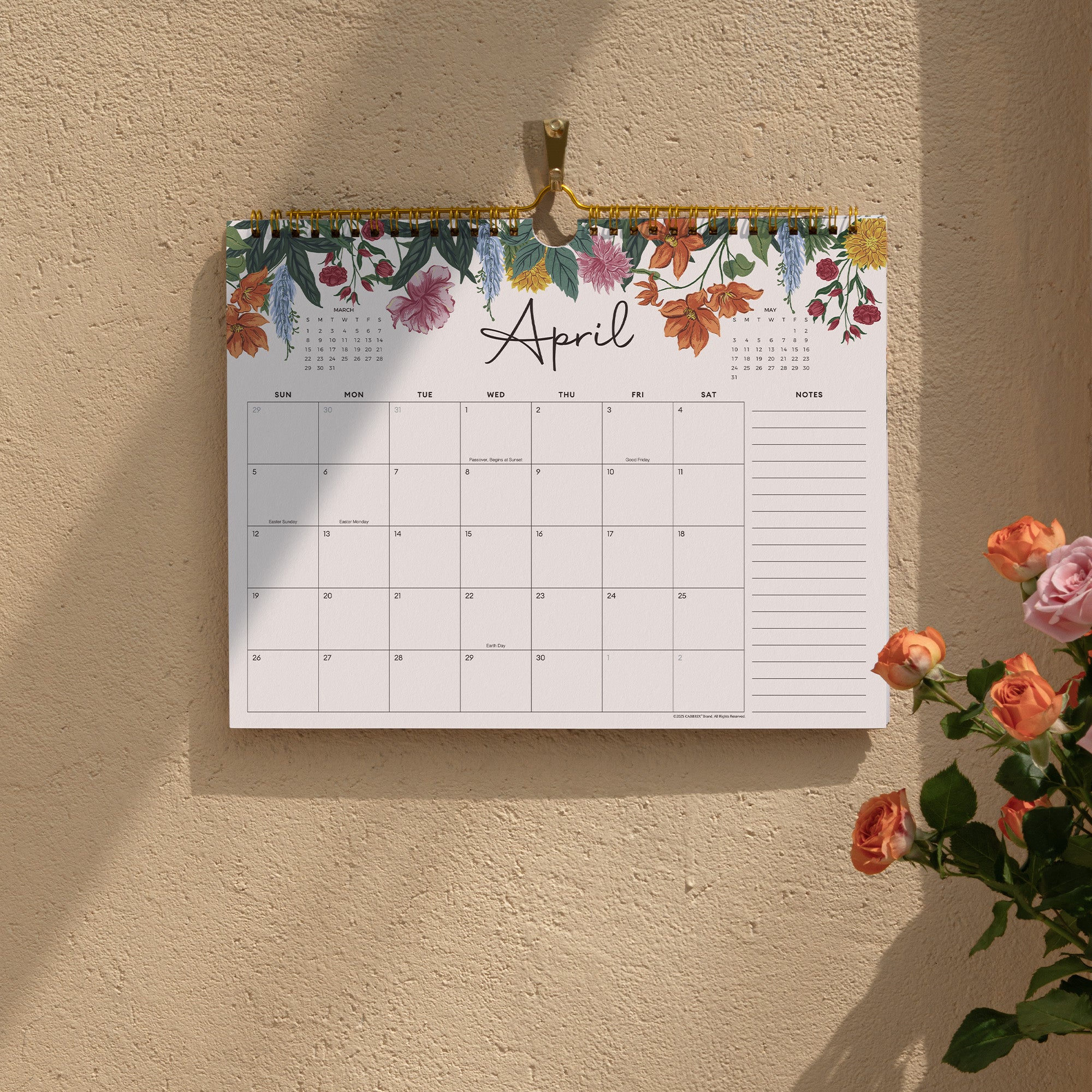 Floral calendar for April on a beige wall with a plant in the corner