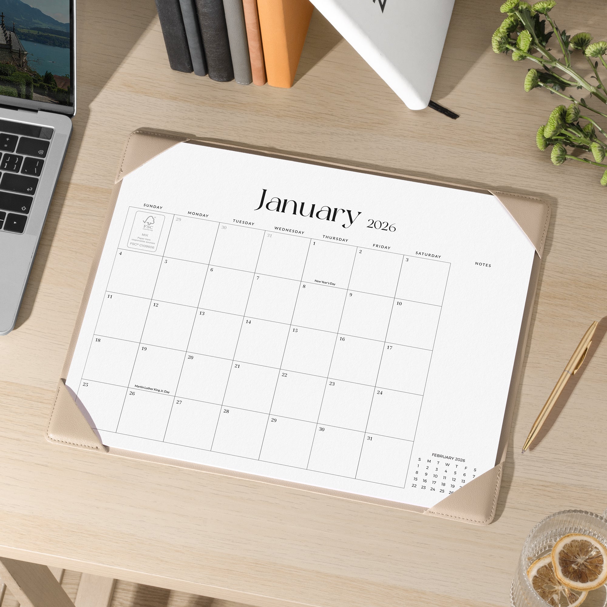 Calendar for January 2026 on a wooden desk with office supplies.