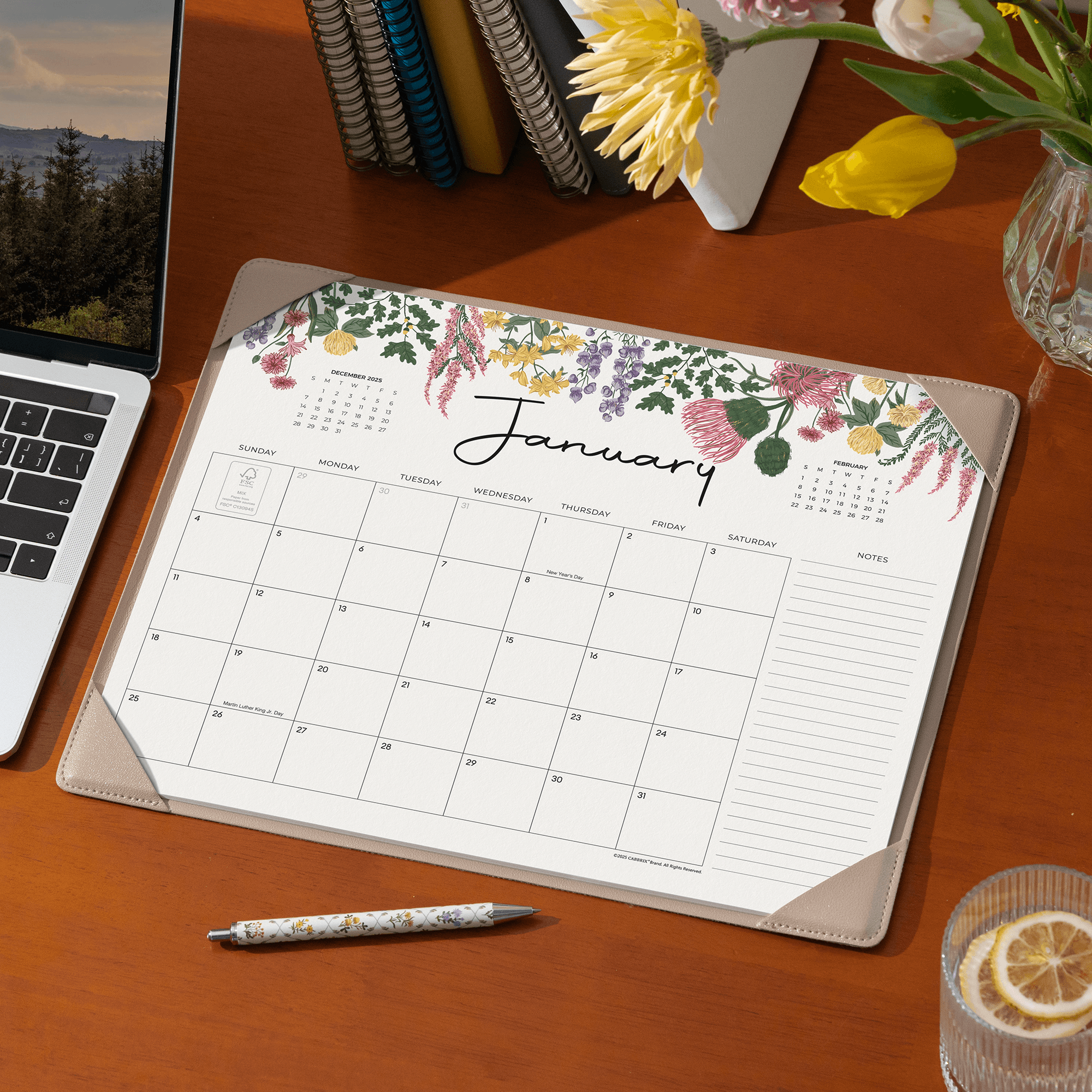 Floral calendar on a desk with a laptop and flowers