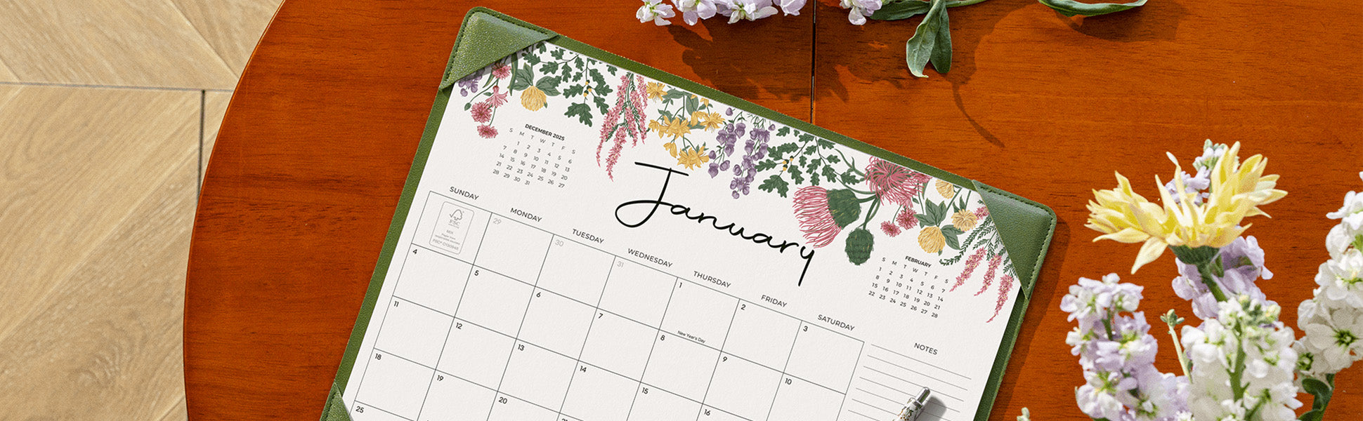 Floral-themed calendar on a wooden table with flowers around