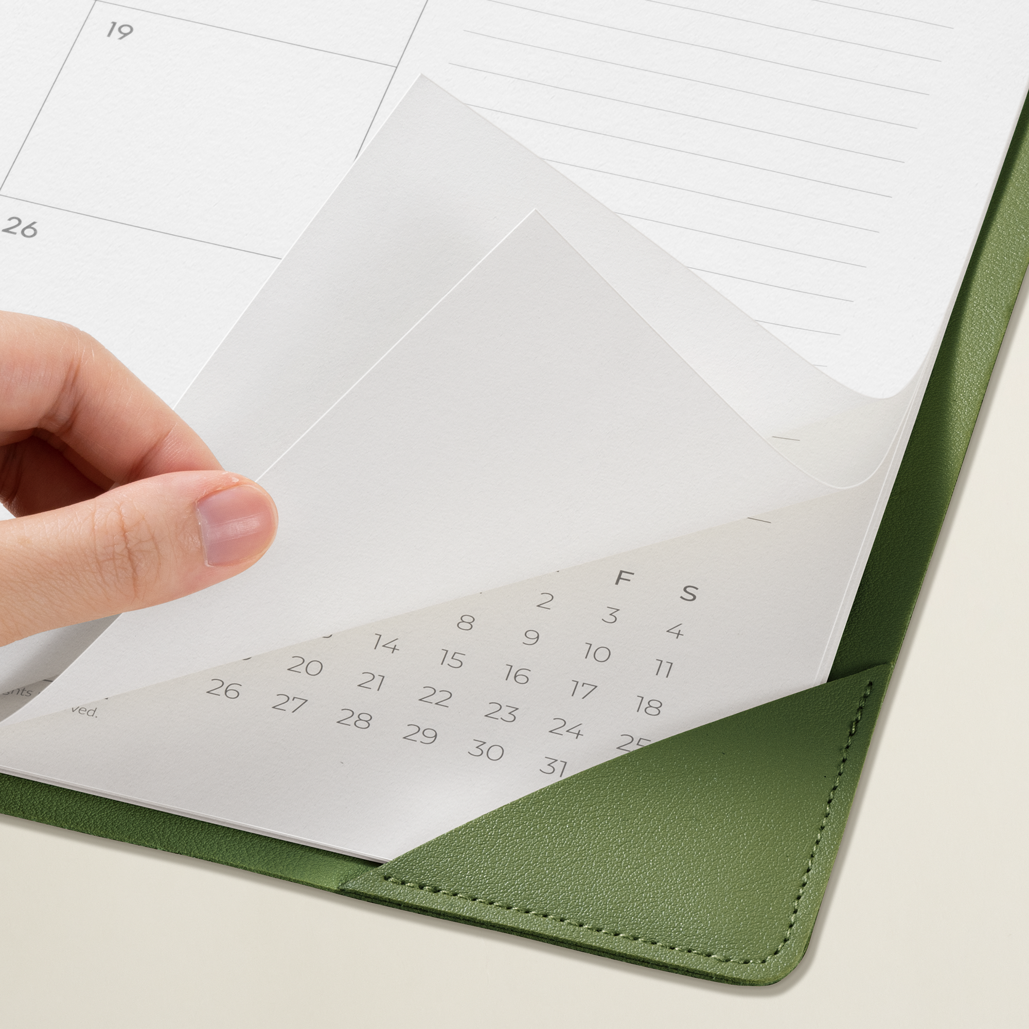 Hand opening a green envelope with a calendar inside on a white background