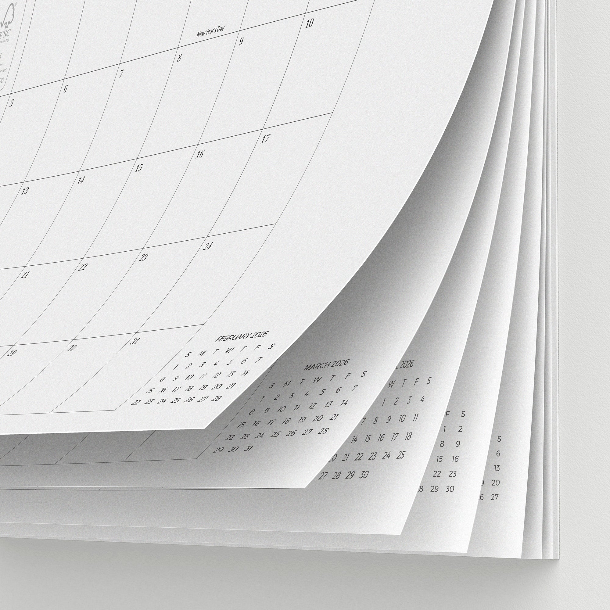 Calendar sheets stacked on a white surface