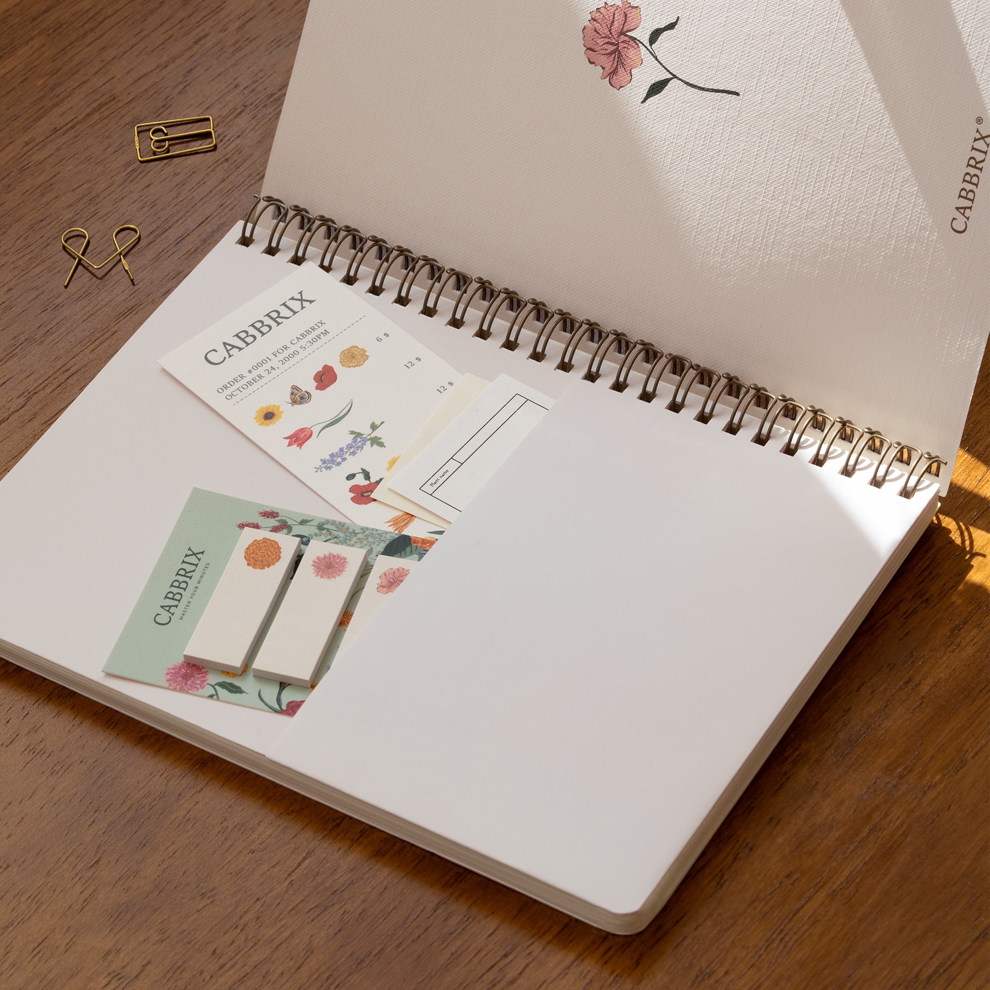 Open notebook with Cabrix stationery items on a wooden surface