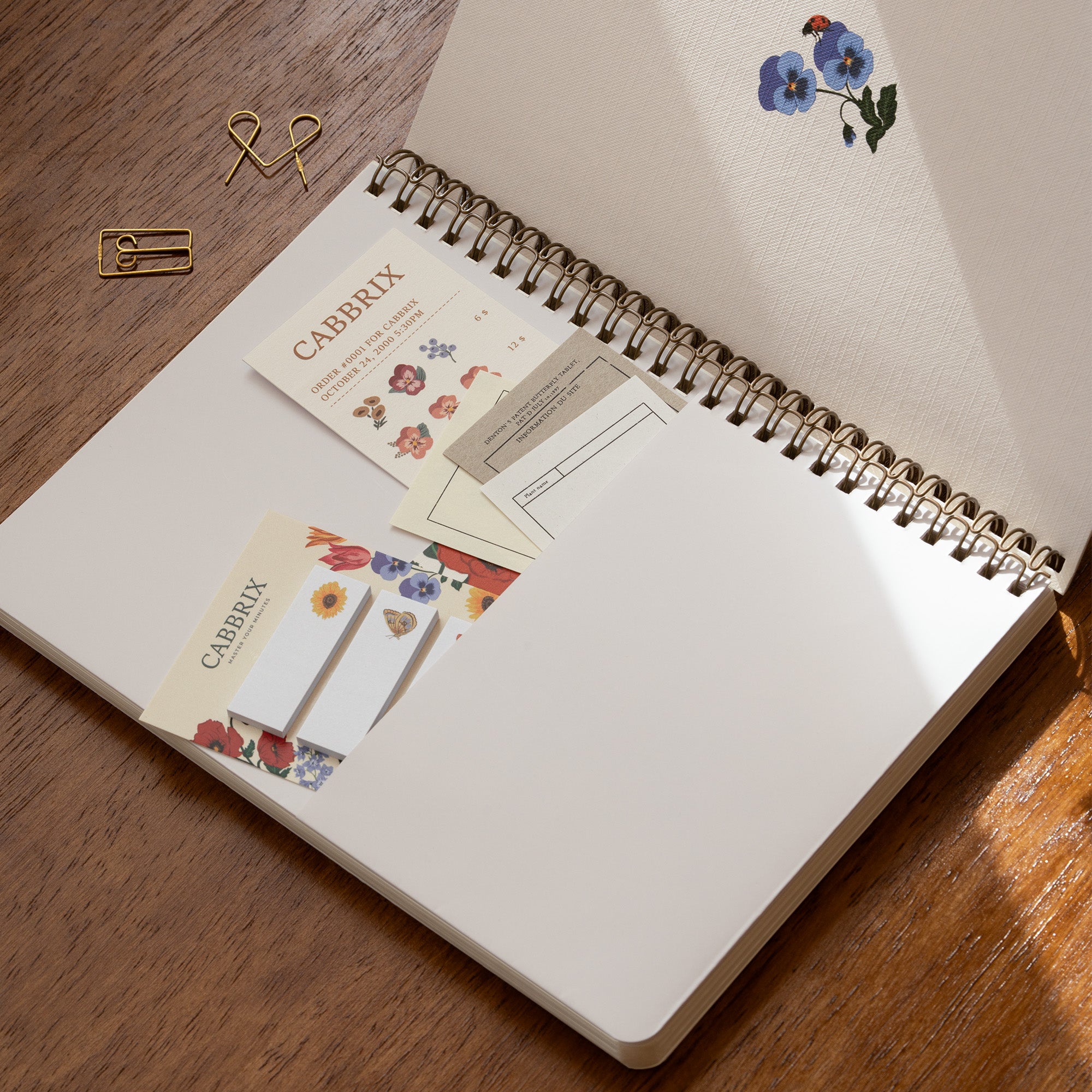 Open notebook with stationery items on a wooden surface