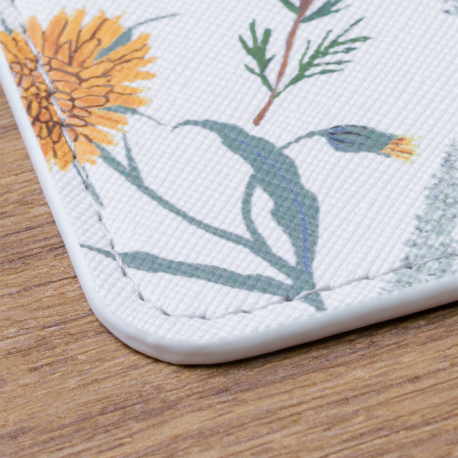 Close-up of a phone case with floral design on a wooden surface