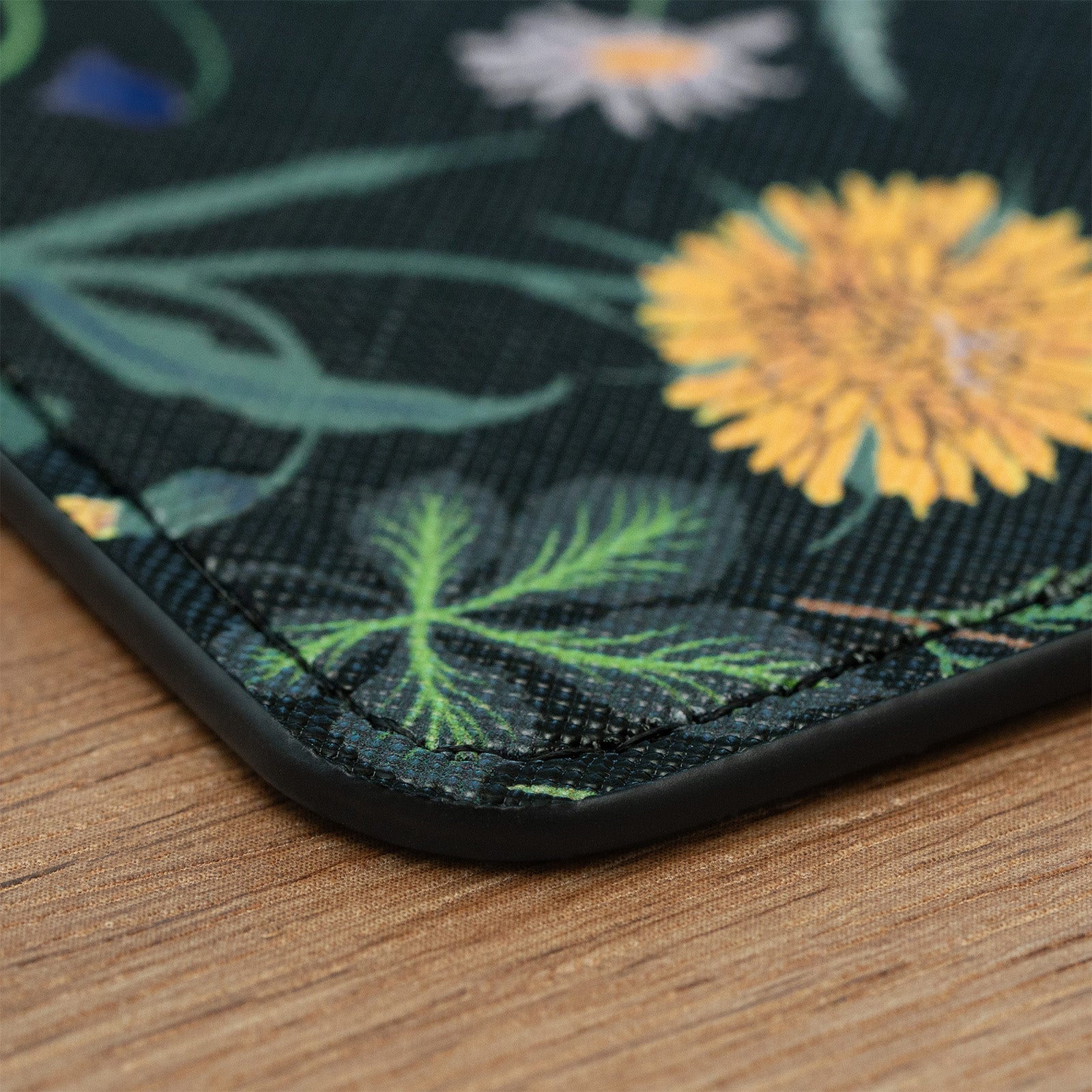 Floral patterned mat with yellow flowers and green leaves on a wooden surface