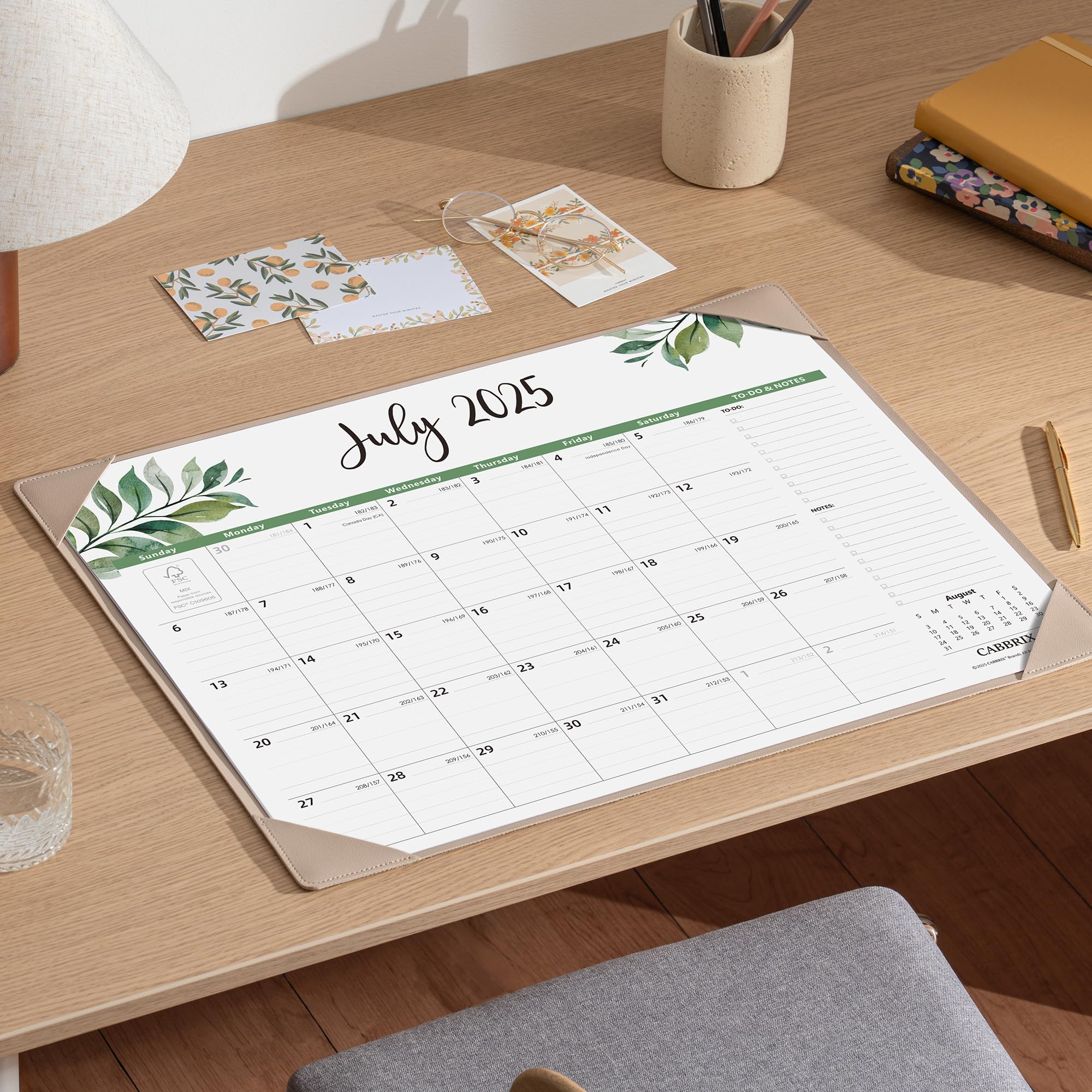 Calendar for July 2025 on a desk with stationery items