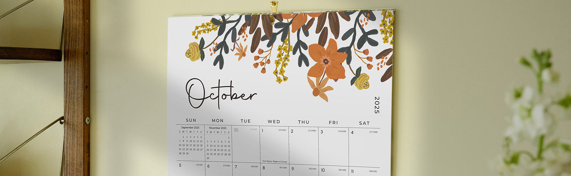 Floral-themed calendar for October on a wall with a neutral background