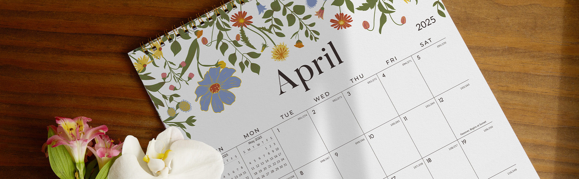 Calendar for April on a wooden surface with flowers.
