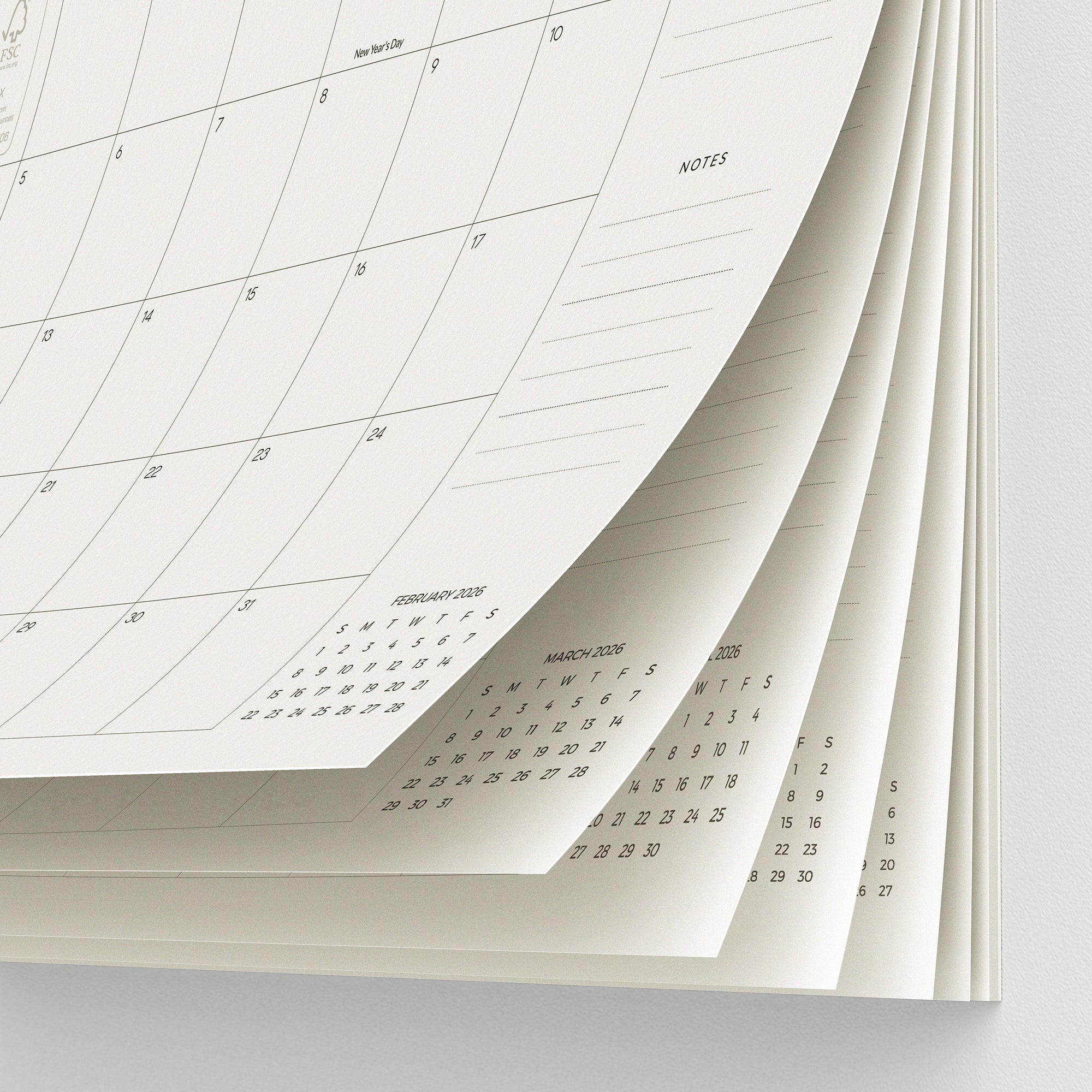 Stack of white calendar pages with grid lines on a light gray background