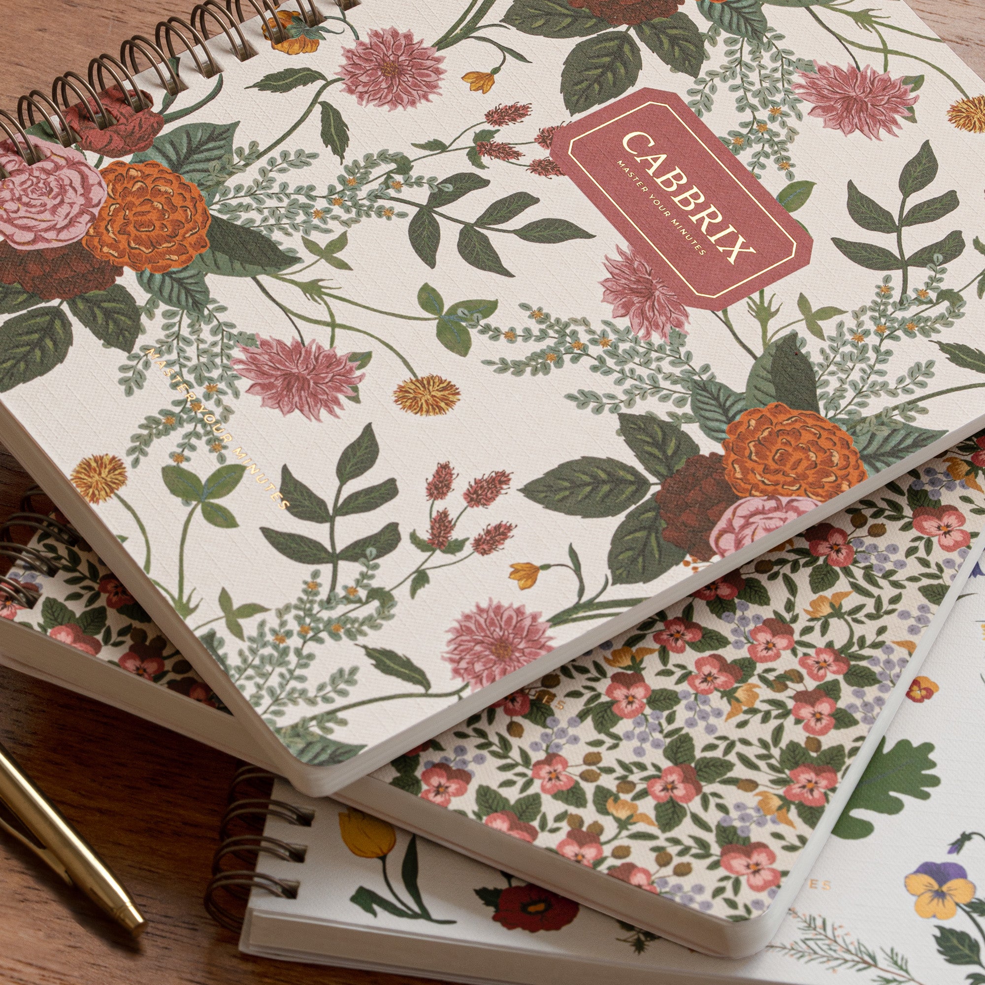 Floral notebook with 'Caberix' branding on a wooden surface
