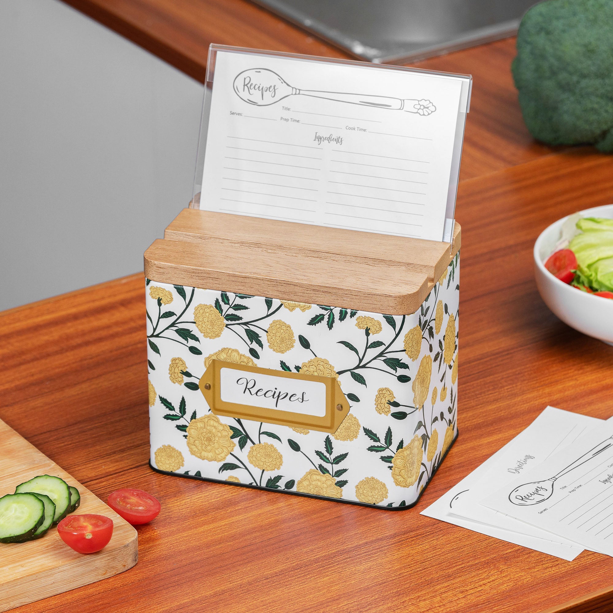 Floral-patterned recipe box on a kitchen counter with recipe cards.