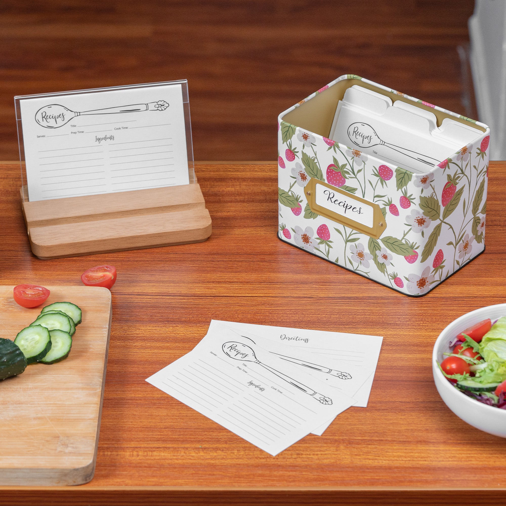 Floral-patterned recipe card holder with recipe cards on a wooden table.