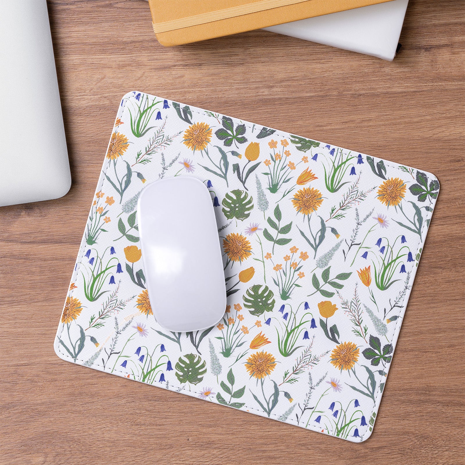 Floral patterned mouse pad on a wooden desk with a computer mouse.