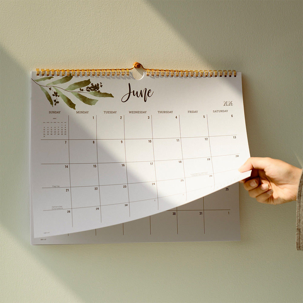 Calendar with a hand turning the page on a light green background