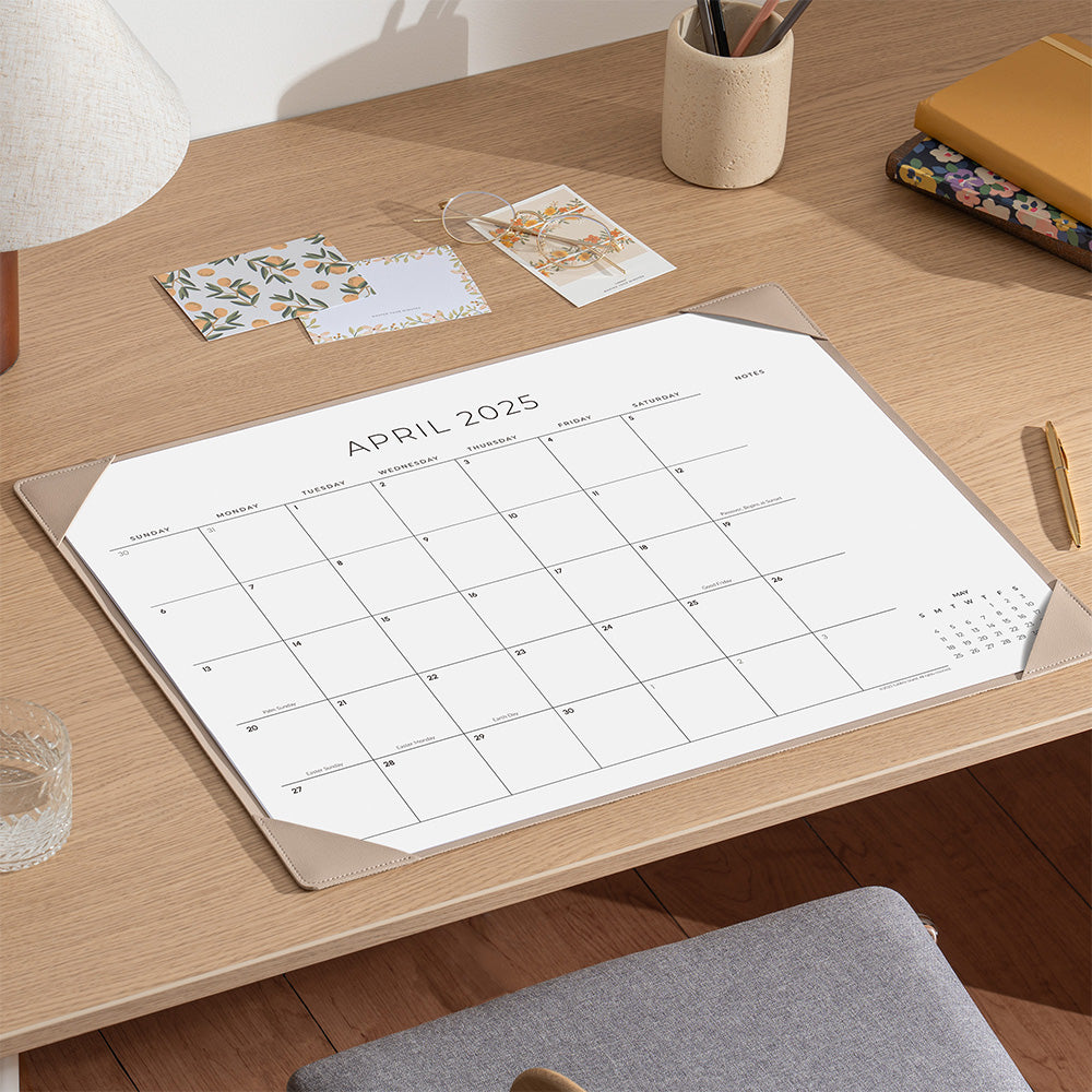 Calendar on a wooden desk with stationery items
