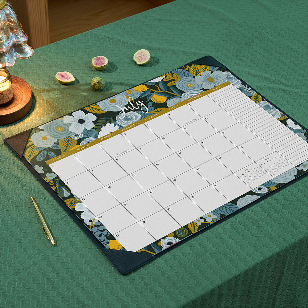 Floral-themed calendar on a green tablecloth with decorative items.